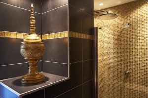 Ins Badezimmer lädt die große Walk in-Dusche mit einer Raindance-Brause ein.