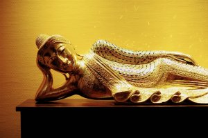 Der liegende Buddha begrüßt die Gäste im Obergeschoß und schmückt die Wände mit unzähligen von Lichtreflexen.