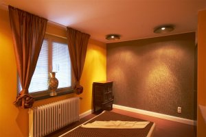 Das Einzelzimmer für die Thai Massage glänzt mit einer opulenten goldenen Tapete.